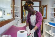 Female daycare worker cleaning changing table surface 