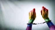 Handcuffed hands painted with gay pride flag