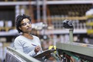 Mid adult, African American woman (30s) working in manufacturing facility