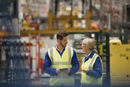 two workers in a factory talking