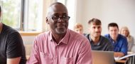 Mature Student Using Digital Tablet In Adult Education Class