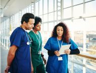 Three hospital workers looking at tablet