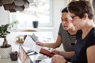 Couple discussing over financial bills while using laptop at table