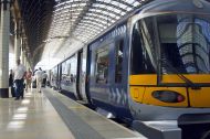 train on a platform with people walking past