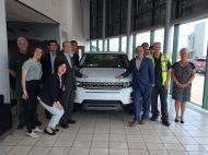 RENGO and TUC officials standing around a Range Rover on a workplace visit