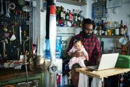 A man at a workshop holding a baby