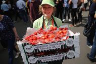Photo of female worker at Wimbledon holding a basket of strawberries