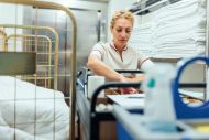hotel worker taking cleaning supplies from trolley