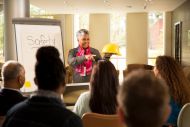 Tutor standing and speaking to adult learners in a class