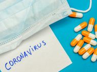 A surgical mask, some tablets, and a written note with 'coronavirus' 
