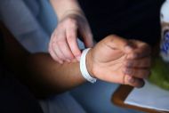 one person'a hand checks the pulse of another person's hand