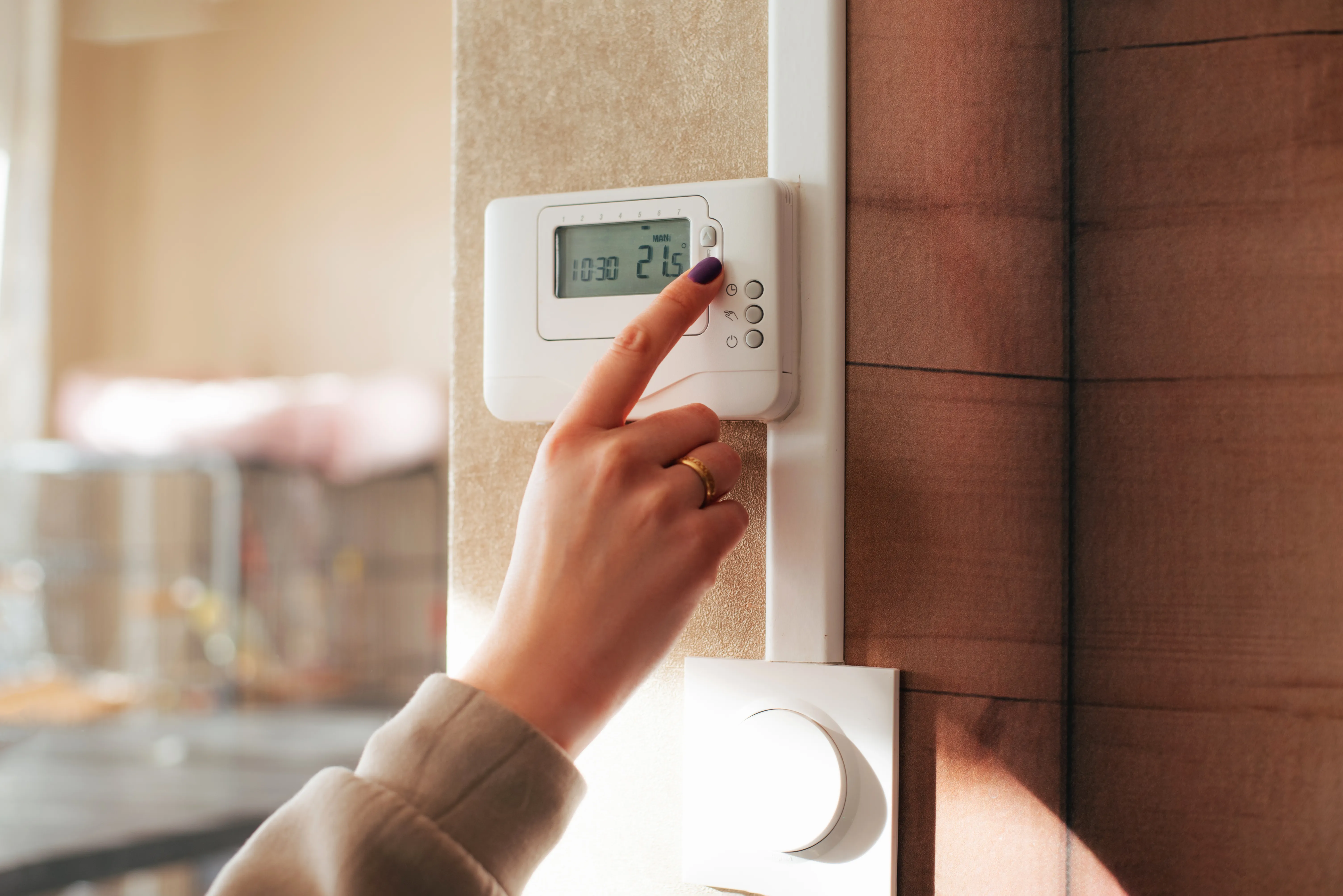 person changing temperature on a thermostat
